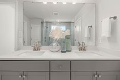 a bathroom with two sinks and a large mirror in it's centerpieces