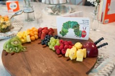 the very hungry caterpillar board is full of fruits and vegetables, along with a book