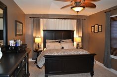 a bedroom with a bed, dresser and ceiling fan