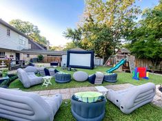 an inflatable movie set is on the lawn next to a backyard play area