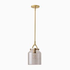 a glass and brass pendant light hanging from the ceiling