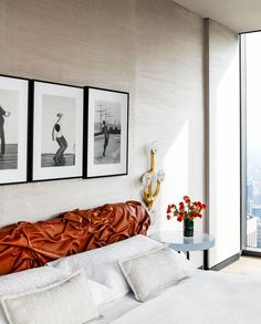 a large bed sitting in a bedroom next to two pictures on the wall above it