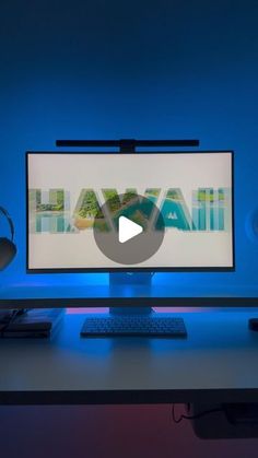 a computer monitor sitting on top of a desk next to a keyboard and mouse in front of a blue wall