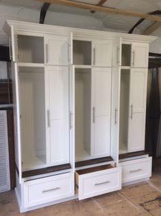 a room with white cabinets and drawers in it