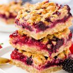 three pieces of berry crumbler bars stacked on top of each other with berries