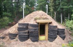 a pile of tires sitting on top of a dirt hill next to trees and bushes