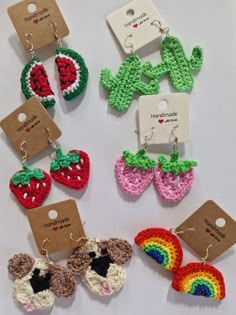 several crocheted items are displayed on a white surface with tags attached to them