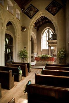 the inside of a church with pews and flowers