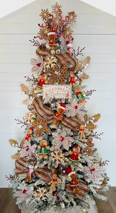 a christmas tree decorated with red, gold and silver ornaments is shown in front of a white wall