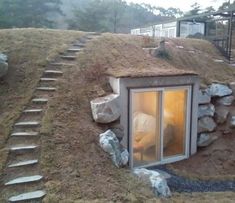 there is a small house made out of rocks and grass on top of the hill