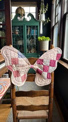 a wooden chair with a quilted butterfly on it