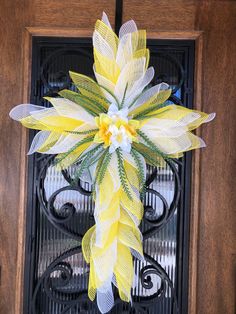 a yellow and white wreath on a door