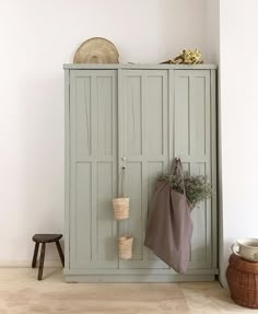 a coat rack with two coats hanging from it's sides next to a stool