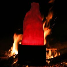 a red bottle sitting on top of a fire