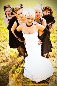 a group of women standing next to each other on top of a grass covered field