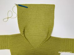 a knitted sweater is being worked on with scissors