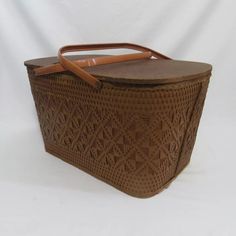 a brown wicker basket with leather handles