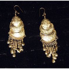 Half-moon gold earrings etched with the image of villagers and animals. Antique Gold Earrings For Festivals, Traditional Round Engraved Earrings, Traditional Engraved Round Earrings, Elegant Engraved Metal Earrings, Ceremonial Gold Earrings, Ornate Bronze Earrings, Engraved Metal Drop Earrings, Traditional Gold Metal Clip-on Earrings, Traditional Brass Dangle Clip-on Earrings