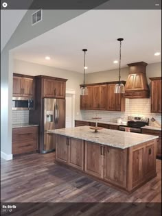 a large kitchen with wooden cabinets and stainless steel appliances