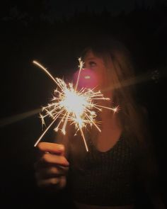 a woman holding a sparkler in her hand