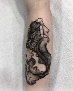 a black and white tattoo on the leg of a woman