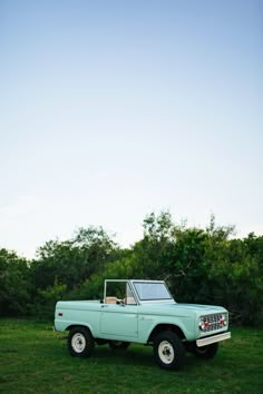 an old pick up truck parked in the grass