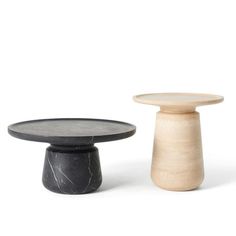 two small black and white pedestals with marble tops