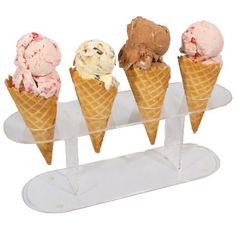 three cones of ice cream on a clear stand with four scoops in each cone