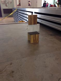 two pieces of wood sitting on top of a floor next to a conveyor belt