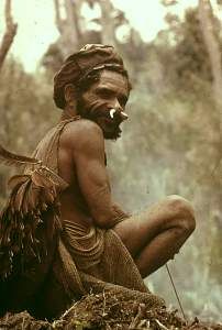 Man relaxing from hard agricultural work -- preparing a plot for planting varieties of sweet potato. Smoke from burning vegetation, returning nutrients to the soil, rises in the background. Man Relaxing, Planting