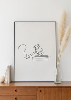 a drawing of a judge's gaven on top of a wooden dresser next to a book