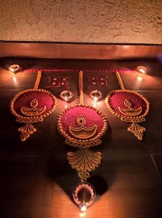 an intricately decorated diya with candles on the floor in front of it,