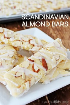 a white plate topped with almond bars on top of a wooden table