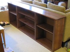 a living room with a couch, book shelf and other items on the floor in front of it