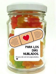 a jar filled with gummy bears sitting on top of a white table next to a sticker