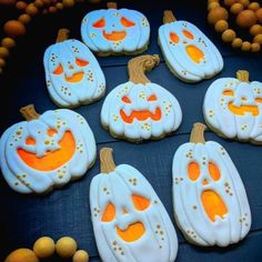 decorated cookies are arranged on a table with pumpkins in the shape of jack - o'- lanterns