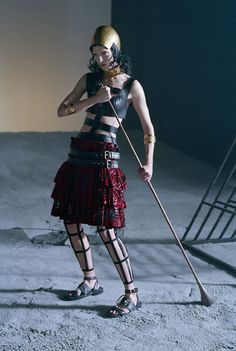 a woman in a skirt holding a broom