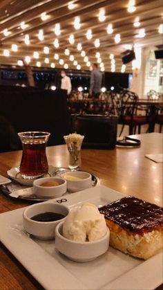 a plate with some food on it and sauces in bowls next to each other