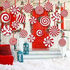 red and white candy canes hanging on the front door of a house decorated for christmas