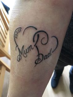 a person with a tattoo on their leg that says mum and dad in the shape of a heart