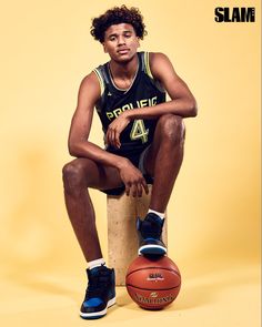 a young man sitting on top of a basketball