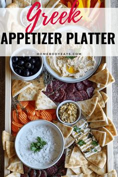 an appetizer platter with crackers, olives, and other foods