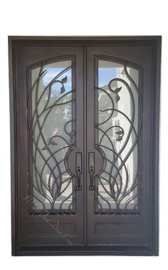 an iron door with glass panels and decorative designs on the front entrance to a house