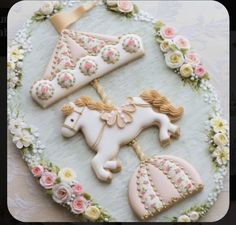 decorated cookies in the shape of unicorns and princesses on a floral platter