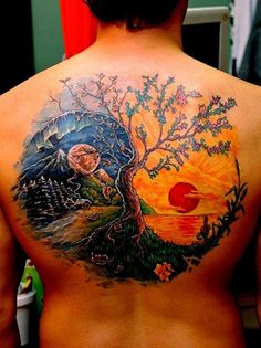 the back of a man with a tree and sunset tattoo