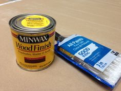 a can of wood finish next to a paint brush