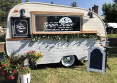 an old camper is decorated with flowers and signs for the sign moon vintage mobile home rentals