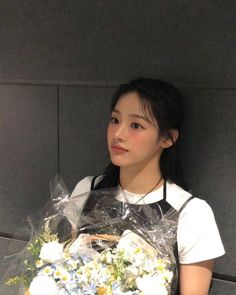 a young woman holding a bouquet of flowers