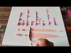 someone is cutting out the letters on a piece of paper with pink crayons