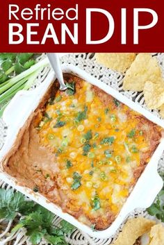 a casserole dish filled with refried bean dip and tortilla chips